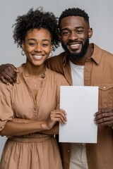 A man and woman holding a blank paper in their hands
