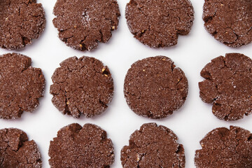 Chocolate peanut butter cookies coated with sugar on white background. Cocoa peanut butter biscuits pattern on white wallpaper. handmade homemade bakery goods. fresh baked goods.