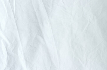 Top view of wrinkles on an unmade bed sheet after waking up in the morning.