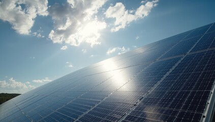 Photovoltaic modules in a solar farm oriented to maximize sunlight capture amid a bright sky