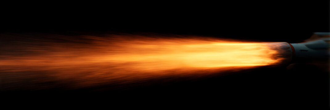Powerful orange rocket engine flame exhaust against black background, high speed jet propulsion energy concept for aerospace technology and innovation themes