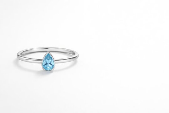Minimalist silver ring featuring natural blue topaz in a teardrop shape and copy space for text