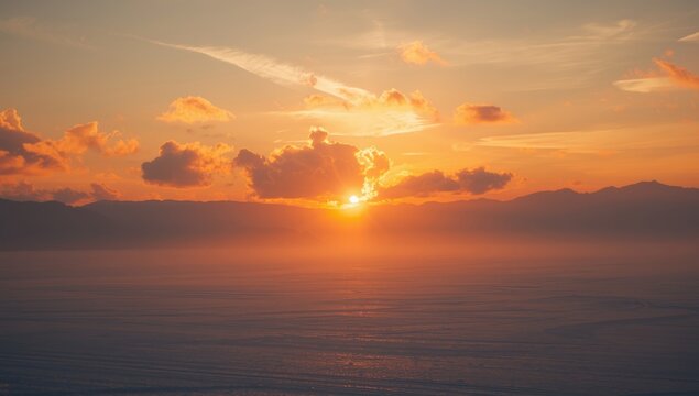 Sunset with orange hues and sun rays piercing clouds above a snow-covered landscape, highlighting winter evening lighting - Powered by Adobe