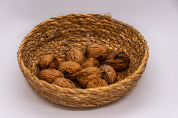 Nueces en una cesta con un fondo blanco.