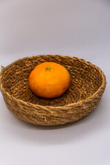 Mandarina en una cesta con un fondo blanco.