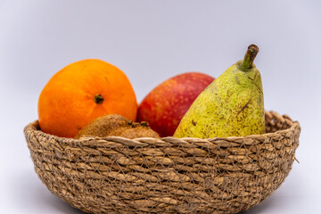 Conjunto de frutas en una cesta con un fondo blanco.