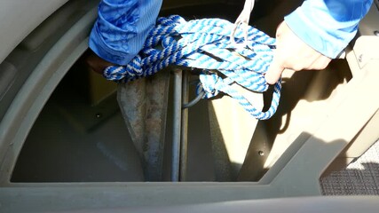 Pontoon boat anchor getting lifted out of storage compartment