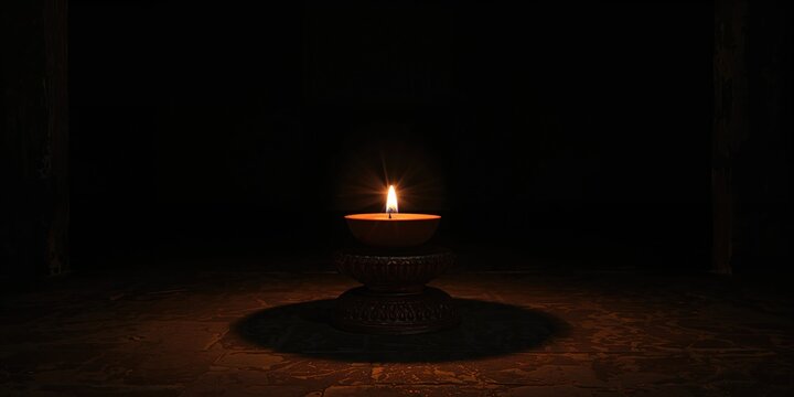 Clay oil lamp placed in a dim Hindu temple setting, serving as a source of devotional light