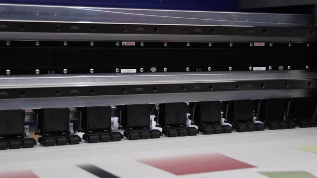 Industry printer. High quality Industrial inkjet printer in operation. printing patterns on large sheet of fabric or paper. Automate printer for modern textile printing and digital print technology.