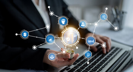 A business professional holds a light bulb symbolizing innovation while surrounded by digital icons representing networking and technology, creating a dynamic office atmosphere. Crux