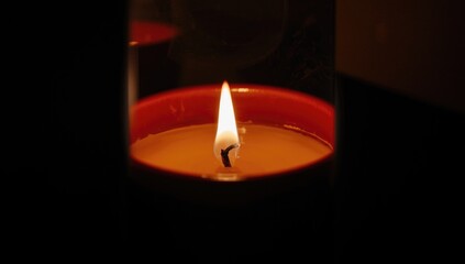 Detailed shot of a burning candle in a ceramic vessel highlighting warm illumination, suitable for atmosphere enhancement