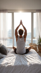 Young man practicing yoga on bed in the morning at home