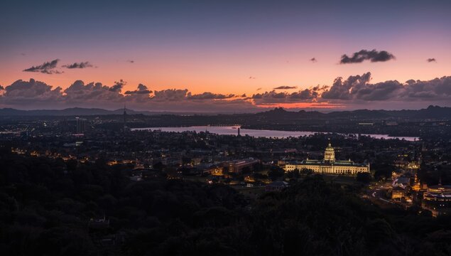 Evening view of Parliament House and Canberra suburbs from Mount Ainslie, highlighting the Australian War Memorial and Lake Burley Griffin, landscape scene