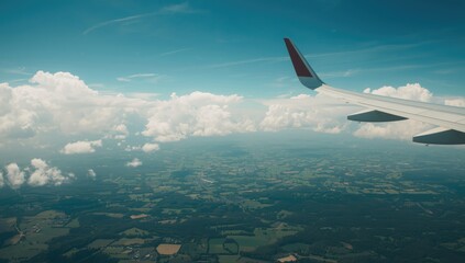 Fototapeta premium Airplane wing in flight above vibrant farmland following departure, highlighting aerial perspective and rural scenery