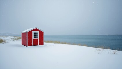 Colorful wooden building adjacent to snow-covered ground and icy sea, highlighting winter environment
