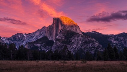 Sunset over rugged mountain landscape with orange sky, suitable for travel and nature backgrounds