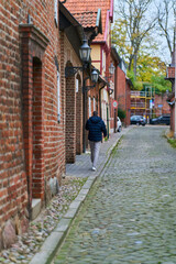 Gasse mit Fussg&auml;nger und alten Geb&auml;uden in der Altstadt von L&uuml;neburg in Deutschland