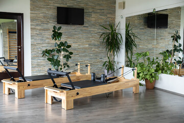 A serene Pilates studio showcases reformer machines surrounded by greenery, creating an inviting...