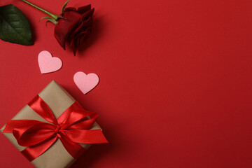 Festive background with a bottle of champagne, two glasses and hearts and gift boxes. A romantic...