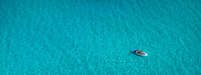 SUP paddleboard on turquoise water aerial top view