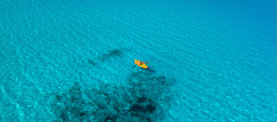 Kayak over clear water above coral reef