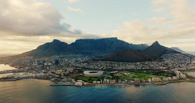 Cinematic aerial view of Cape Town Sea Point district in South Africa. Stadium, mountain peaks, urban landscape and coastal cityscape in soft daylight. Establishing 4K drone zoom in shot
