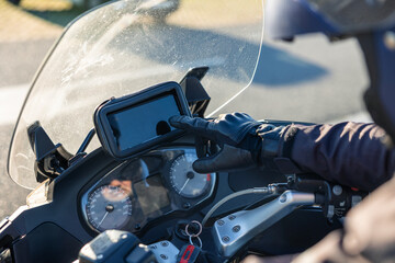 Motorcyclist using smartphone navigation system on dashboard