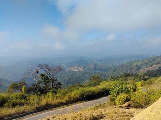 Beautiful Mountain Landscape with Winding Road and Misty Forest Hills