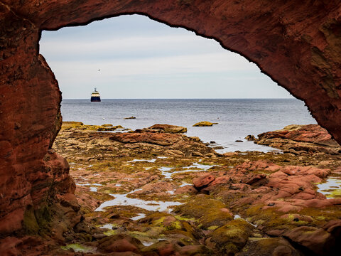 Fraserburgh coastal cave framing ocean view with ship