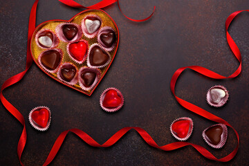 Heart-Shaped Box of Assorted Chocolates with Red Ribbons on Rustic Background