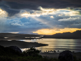 Dramatic sunset over Scottish lake with storm clouds