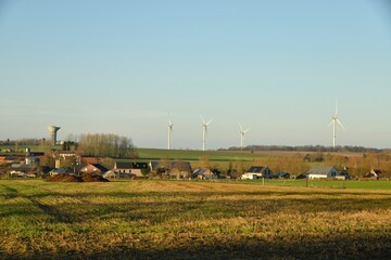 Le village de Ghislenghien et le parc &eacute;olien sous un ciel bleu en fin de journ&eacute;e &agrave; Ghislenghien (Ath)