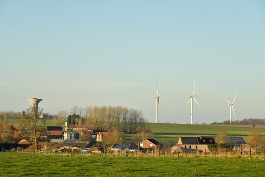 Le village de Ghislenghien et le parc &eacute;olien sous un ciel bleu en fin de journ&eacute;e &agrave; Ghislenghien (Ath)