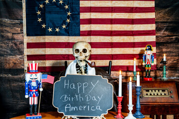 skeleton smoking pipe holding happy birthday sign with tea stain colonial American flag background