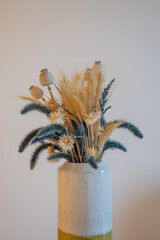 Bouquet de fleurs s&eacute;ch&eacute;es et gramin&eacute;es dans un vase minimaliste, concept de d&eacute;coration int&eacute;rieure boh&egrave;me
