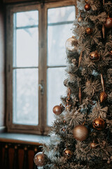 Sapin de Noel d&eacute;cor&eacute; pr&egrave;s d'une fen&ecirc;tre avec lumi&egrave;re douce d'hiver 
