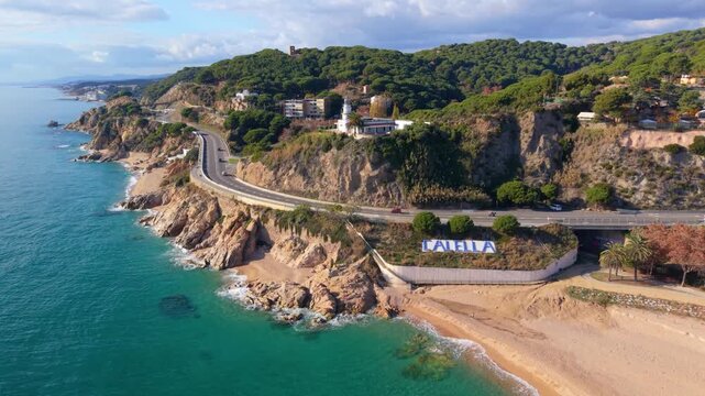 Aerial drone flying over calella spain coastline and lighthouse