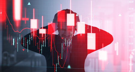 Stressed investor holding head in front of red stock chart showi