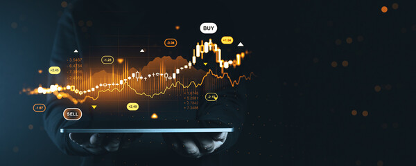 Digital forex stock market graph and candlestick chart data with buy and sell signals displayed as glowing hologram above tablet in dark background..