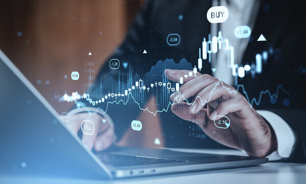 Businessman analyzing stock market data using laptop with digital forex and crypto trading graphs and futuristic hologram interface on screen. - Powered by Adobe
