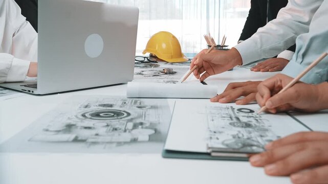 A dynamic scene of professionals collaborating in a creative workspace, featuring tools and sketches, highlighting the design process in engineering and construction projects. SACTR