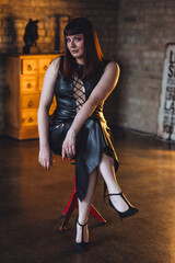 Sexy elegant beautiful gorgeous self confident plus size middle age woman in the leather black dress. Body positive concept