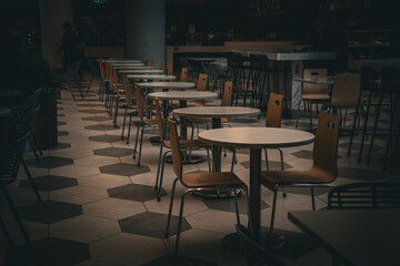 Empty dining area with tables and chairs arranged neatly on a geometric tiled floor © Tom