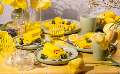 Yellow crepes with blueberries and mint for a festive breakfast