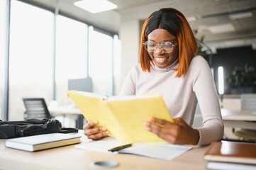 african american girl student studying at university at desk. Concept of higher education