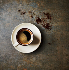 Cup of black coffee on a rusty stone background. Top view. Copy space