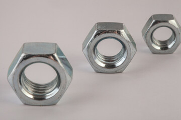 Steel hex nuts stack tower on white background for industrial business concept and construction balance. Vertical row of metallic fasteners representing strength stability and engineering precision