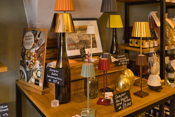 Dekorative LED-Flaschenlampen und regionale Spezialitäten im Verkaufsregal des Genusskontors am...