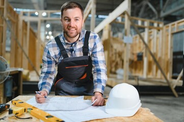 Construction of modular houses. An architect on a construction site looks at a blueprint
