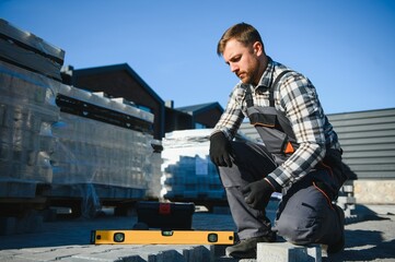 Professional paver worker lays paving stones in layers for pathway, Labor and industry concept